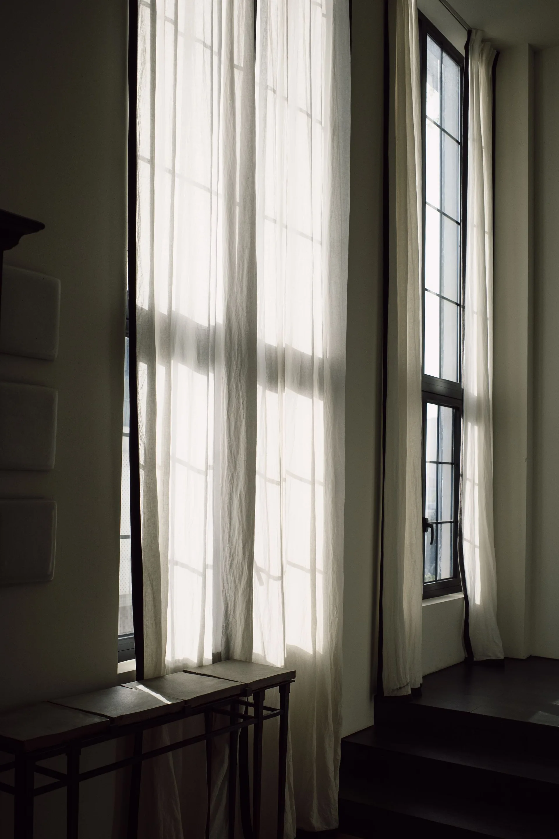 Daylit sheer curtains falling naturally beside tall windows and the floor